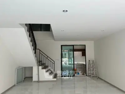 Spacious modern living room with staircase and open kitchen layout