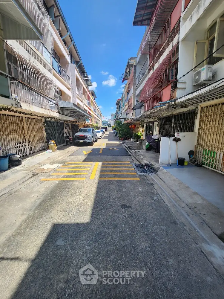 Charming urban street view with vibrant buildings and clear blue sky, perfect for city living enthusiasts.