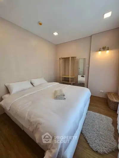 Cozy bedroom with plush bedding and warm lighting, perfect for relaxation and comfort.