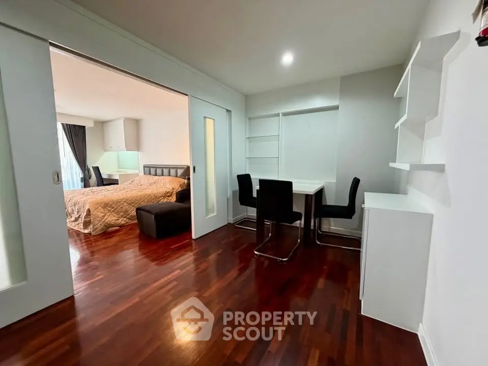 Spacious modern bedroom with study area and elegant wooden flooring