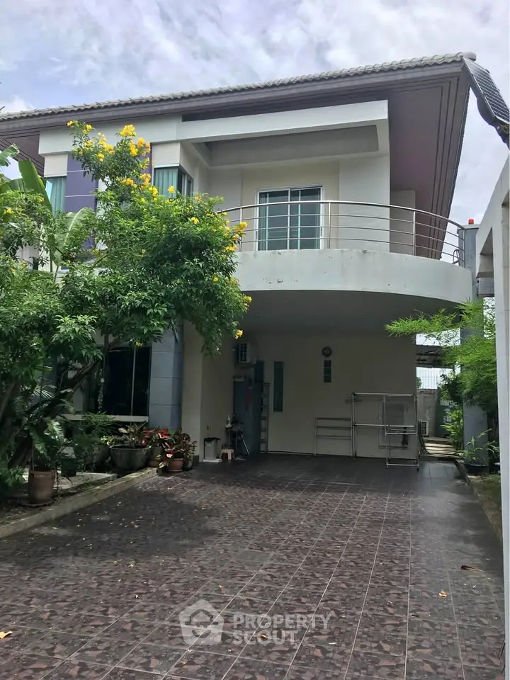 Modern two-story house with spacious driveway and lush greenery