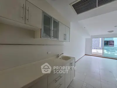 Spacious modern kitchen with sleek cabinetry and city view balcony access.