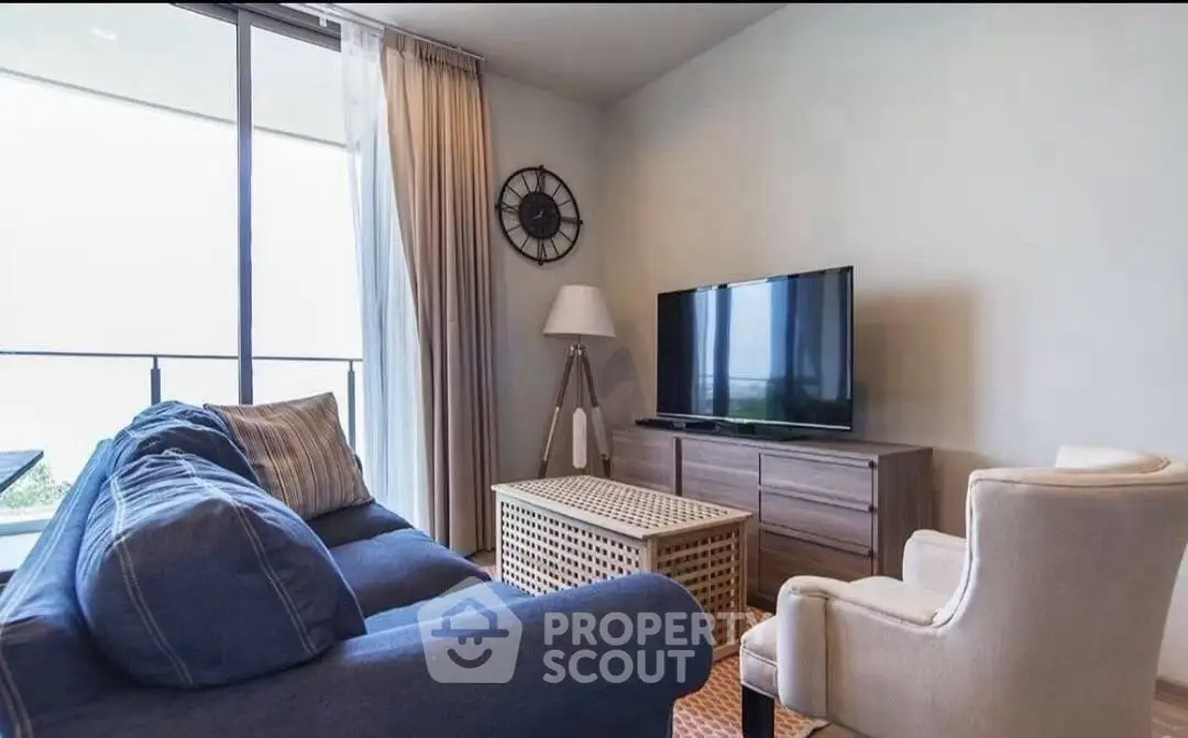 Cozy living room with modern furniture and large window offering natural light.