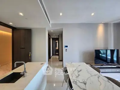 Modern open-plan living room with sleek kitchen and marble dining table