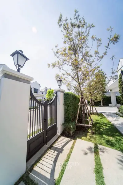 Elegant gated entrance with lush landscaping and modern architecture