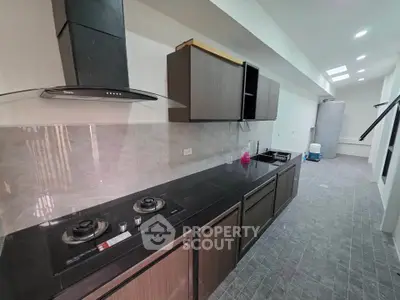 Modern kitchen with sleek black countertops and gas stove in a spacious open layout.
