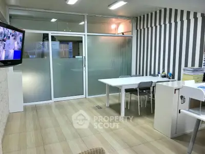 Modern office space with glass partitions and stylish striped walls, ideal for professional meetings.