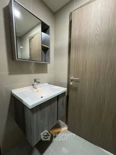 Modern bathroom with sleek vanity and mirror cabinet in contemporary design.