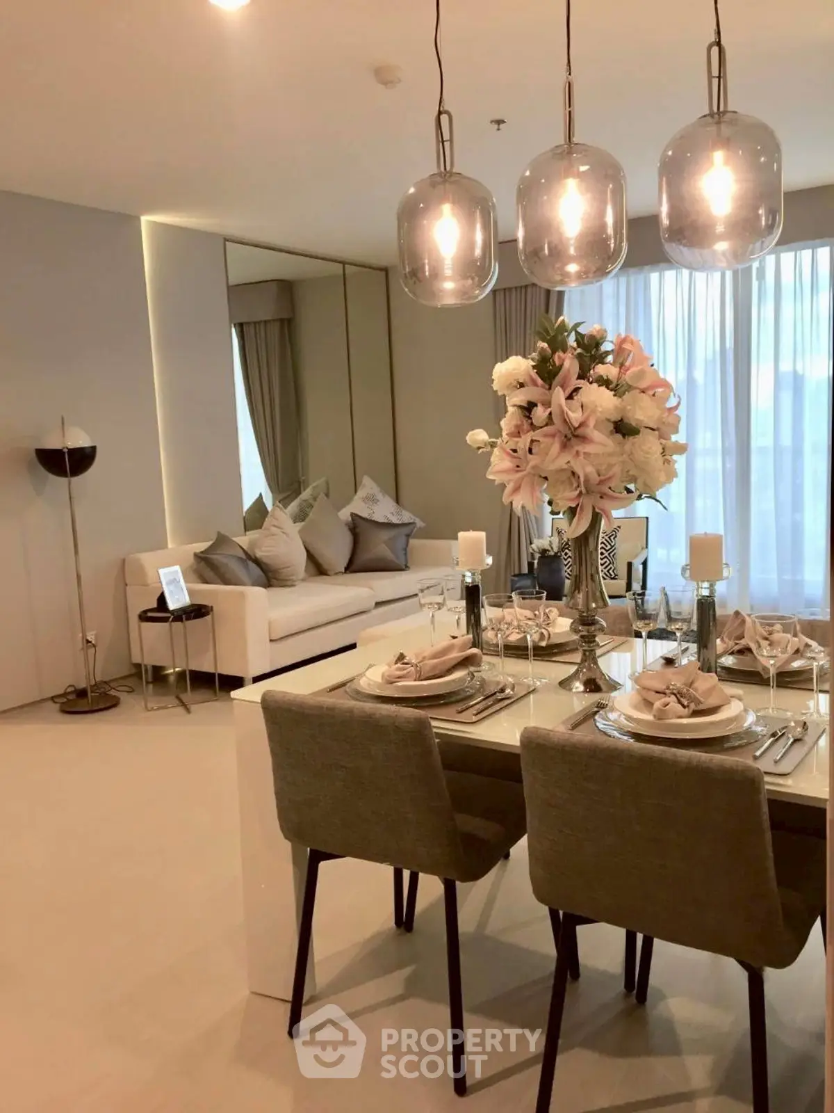 Elegant modern living room with stylish dining area and chic lighting fixtures.