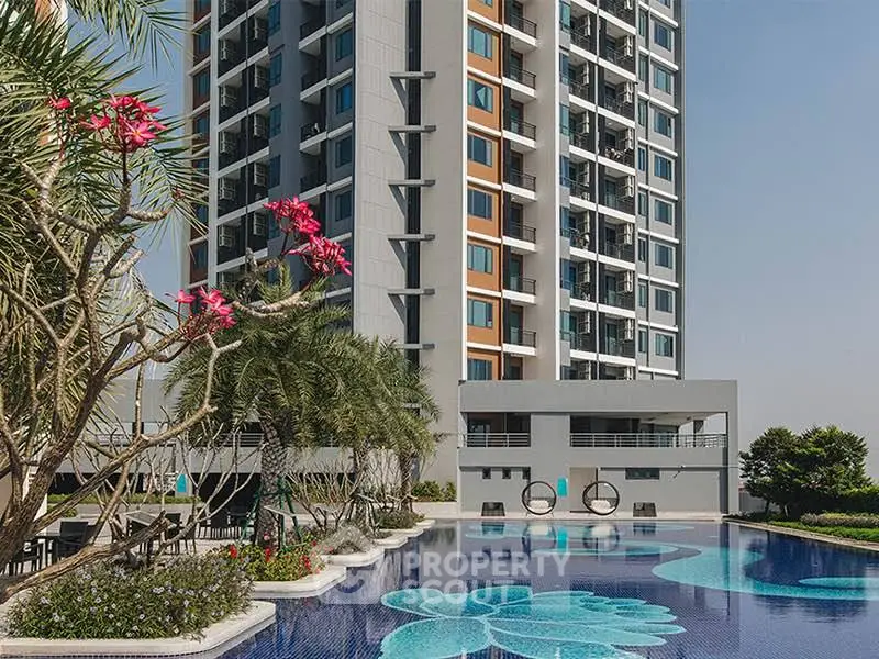 Luxurious high-rise building with stunning pool and lush landscaping, perfect for modern living.
