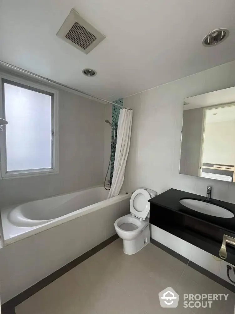 Modern bathroom with bathtub and sleek fixtures in a bright, airy space.