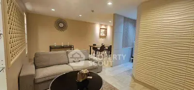 Stylish living room with modern decor and elegant dining area, featuring a cozy sofa and chic wall design.