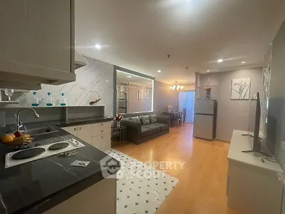Spacious open-plan living room and kitchen with modern decor and hardwood floors.