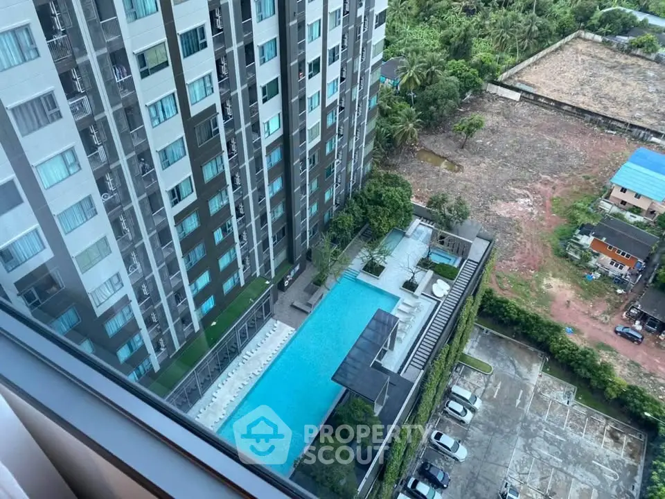 High-rise building with pool and parking view from above, showcasing modern urban living.