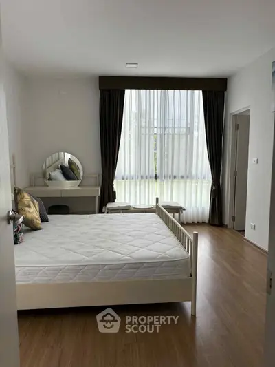 Spacious bedroom with elegant decor and large window for natural light