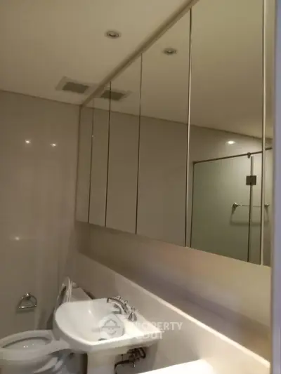 Modern bathroom with sleek fixtures and large mirror cabinets