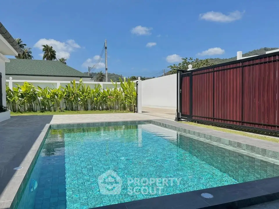 Stunning private pool with lush greenery and modern fencing in a serene residential setting.