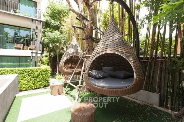 Luxurious garden with unique hanging wicker chairs and lush greenery