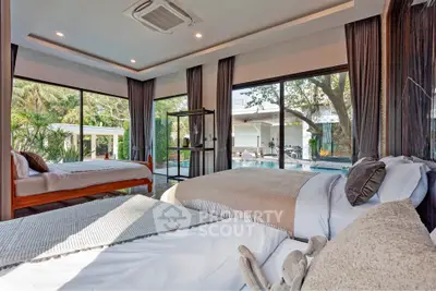 Luxurious bedroom with pool view and modern decor in a serene setting.