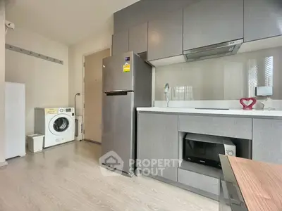 Modern kitchen with sleek cabinetry, stainless steel appliances, and in-unit washer for convenience.