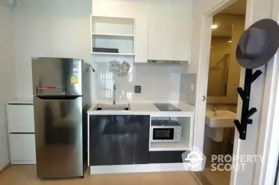 Compact modern kitchen with stainless steel appliances, sleek cabinetry, and a convenient layout for efficient cooking in a cozy urban apartment.