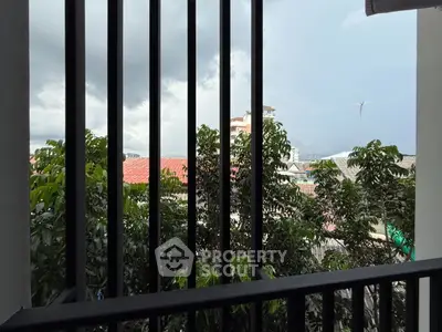 Charming balcony view with lush greenery and cityscape backdrop