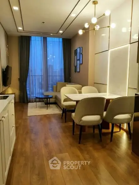 Luxurious modern living room with elegant dining area and city view, featuring stylish lighting and wooden flooring.