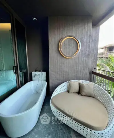 Luxurious balcony with modern bathtub and cozy seating area, perfect for relaxation.