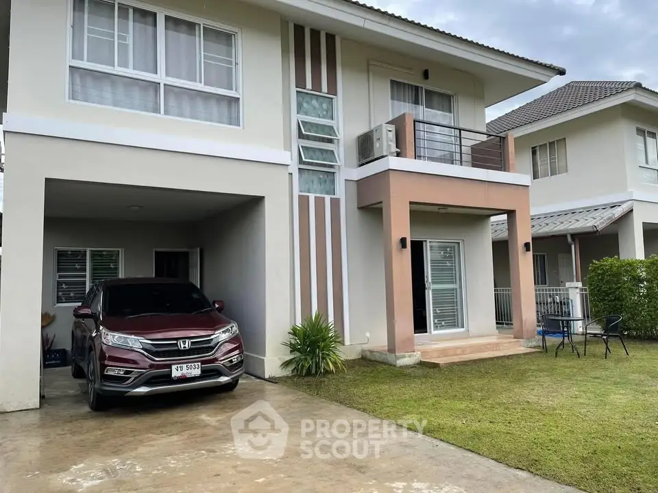 Modern two-story house with driveway and car parked, featuring a small balcony and lawn.