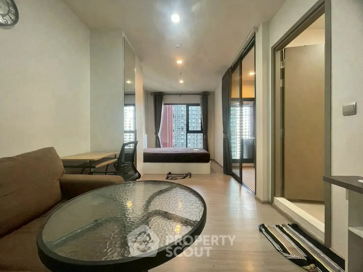 Modern studio apartment with open layout and city view, featuring a cozy living area and bedroom.