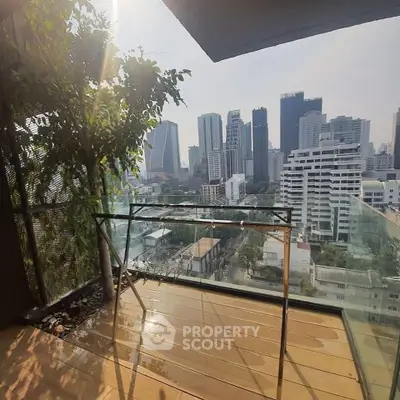 Stunning city view from a modern balcony with glass railing and urban skyline.
