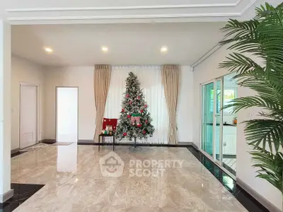 Spacious living room with elegant marble flooring and festive Christmas tree decor.