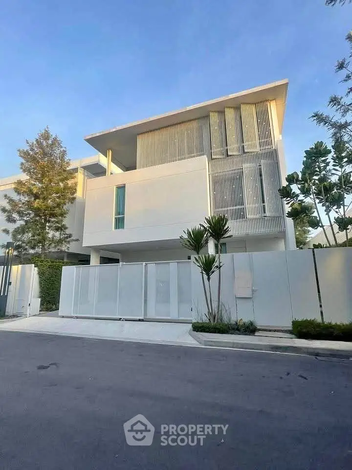 Modern minimalist white house with sleek design and lush greenery