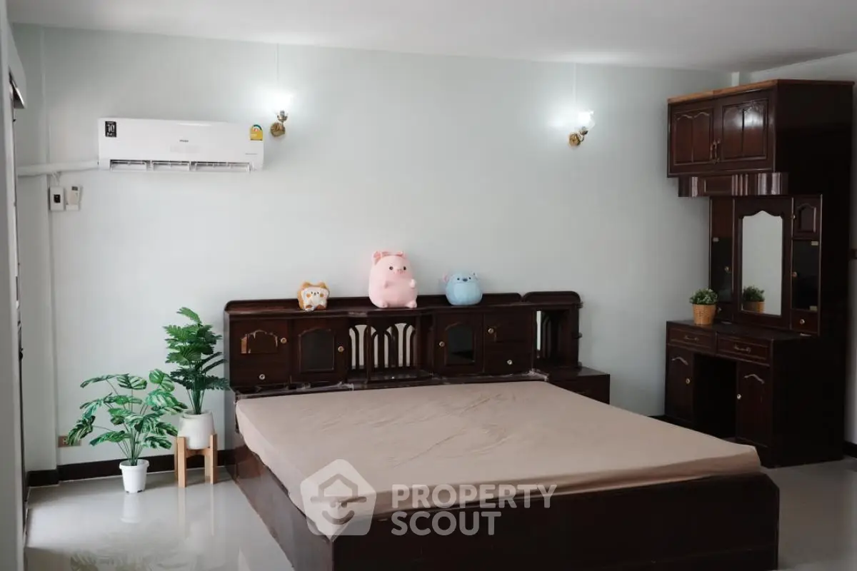 Spacious bedroom with elegant wooden furniture and air conditioning