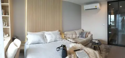 Modern bedroom with cozy decor, featuring a plush bed, stylish sofa, and air conditioning for ultimate comfort.