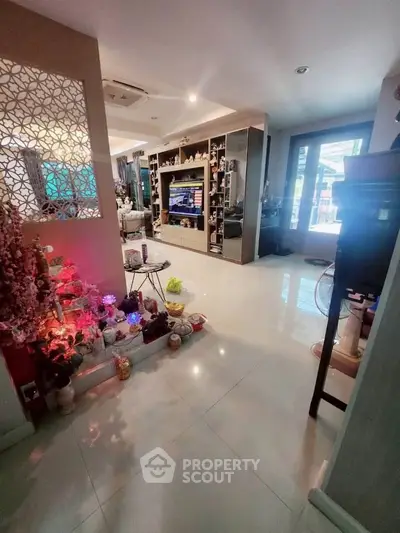 Spacious living room with modern decor and entertainment center, featuring elegant lighting and stylish furnishings.
