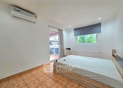 Spacious bedroom with large window and air conditioning, featuring a minimalist design.