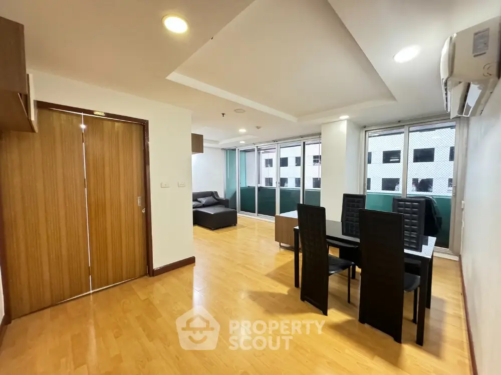Spacious living room with modern dining area and wooden flooring
