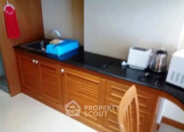 Compact kitchen with wooden cabinets and modern appliances