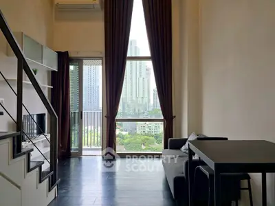 Modern loft apartment with high ceilings and city view, featuring a cozy living area and stylish decor.