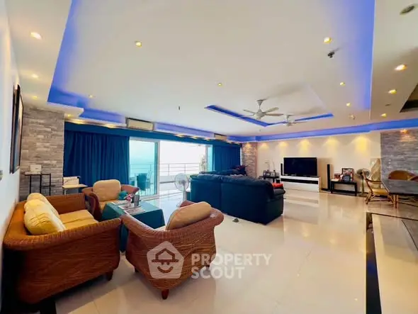 Spacious living room with modern lighting and ocean view balcony.