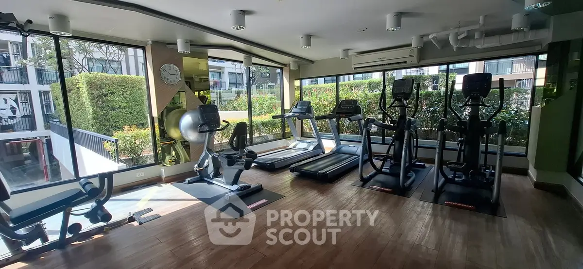 Modern gym with state-of-the-art equipment and large windows offering garden views.