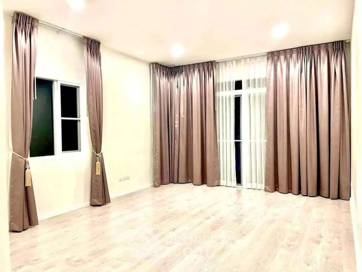 Spacious empty room with elegant curtains and wooden flooring