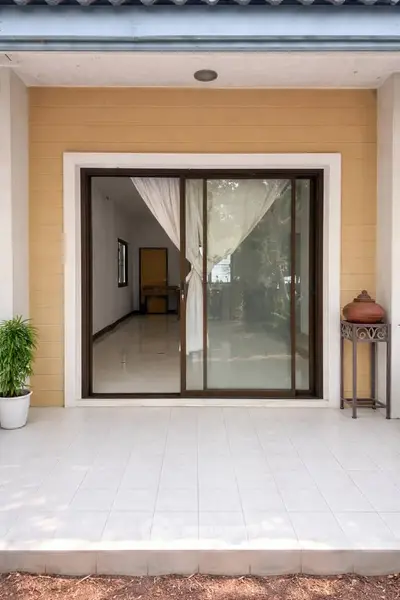Charming entrance with sliding glass doors and tiled patio, perfect for indoor-outdoor living.