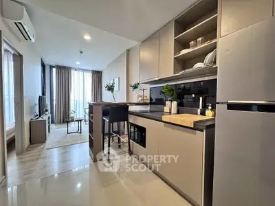Modern open-layout kitchen and living room with sleek design and natural light.