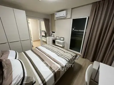Modern bedroom with stylish decor, featuring a comfortable bed, air conditioning, and a large window with curtains.