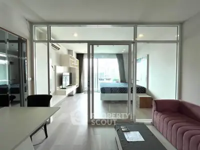 Modern open-plan living room with glass partition and stylish furniture in a contemporary apartment.