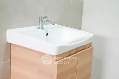 Modern bathroom sink with sleek wooden cabinet and chrome faucet