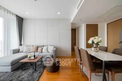 Modern living room with stylish decor and dining area, featuring a cozy sofa and elegant dining table.
