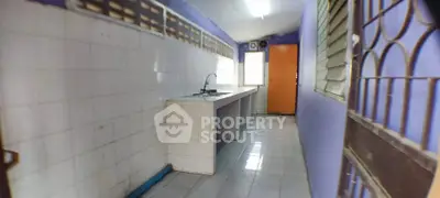 Spacious kitchen with tiled walls and countertops, featuring a single sink and bright lighting.
